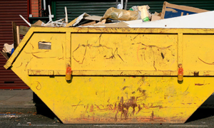 Yellow domestic skip loaded on a residential driveway in Bristol